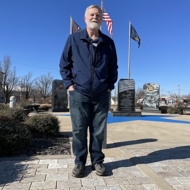 Robert Gruber, standing at the Baxter Springs, Kansas war memorial where his name is inscribed for his service.